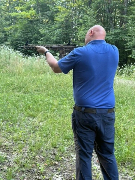 Justin outdoors with a rifle